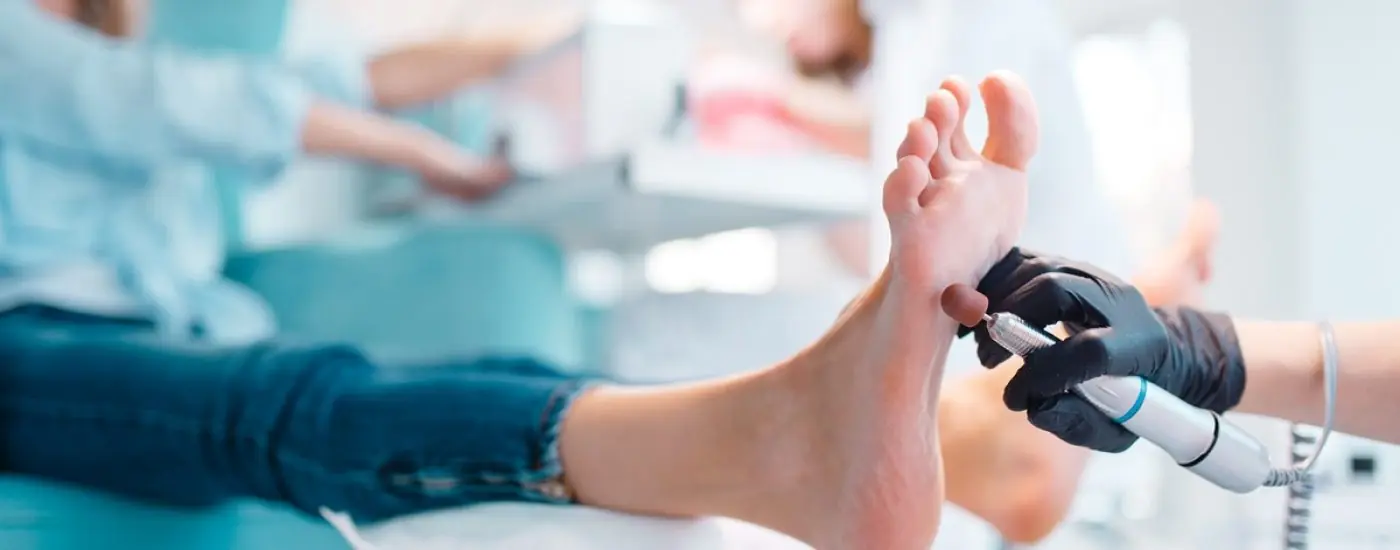 Beautician salon, foot polish procedure. Legs care treatment for female client in beauty shop, master in gloves works with customer, relaxation